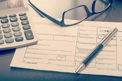 Calculator, glasses and a 1099-MISC tax form on a desk