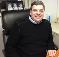 Robert A. Weiss, CPA, smiling at his desk